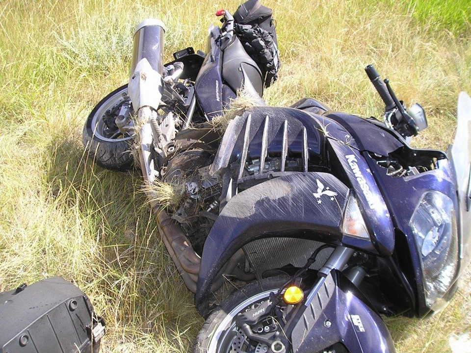 Deep blue Kawasaki Concours lying in a field after crashing