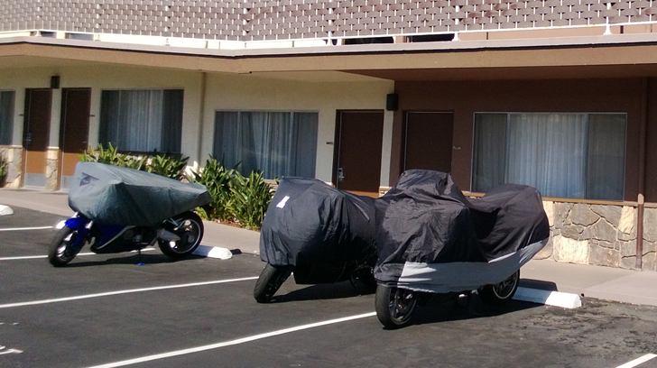 Sport Touring motorcycles covered for security in a motel parking lot 