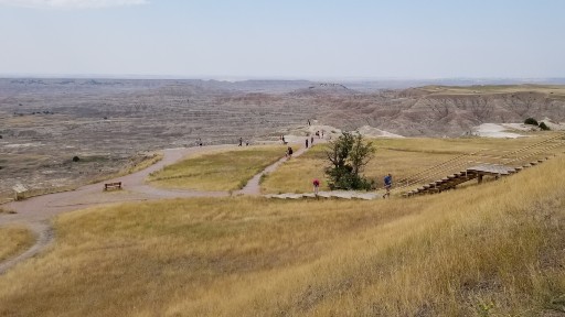 People walking on trails overlooking Badlands National Park 