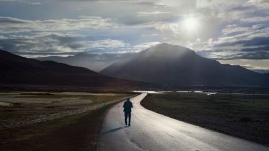 Man walking on a deserted road.