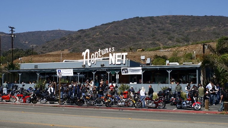 Neptune's Net seafood restaurant with a crowd of motorcyclists gathered in front