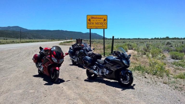 Sport Touring riders passing the Welcome to New Mexico border sign