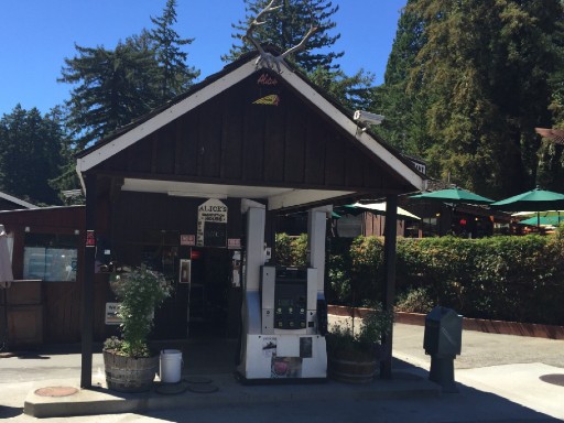 A modern gas pump framed by an early 20th century building.  