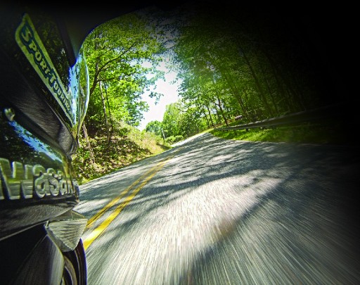 The Tail of the Dragon under a canopy of trees from the rider's perspective    