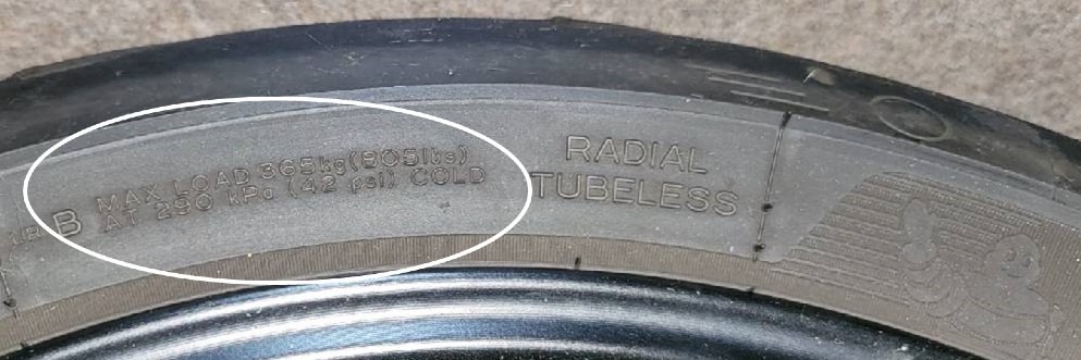 Tire sidewall showing max air pressure recommendation.