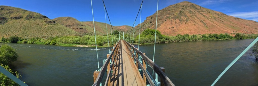 Looking across the Yakama River on a suspended foot bridge.