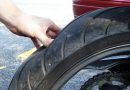 Hand pressing on motorcycle tire.