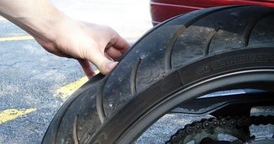 Hand pressing on motorcycle tire.