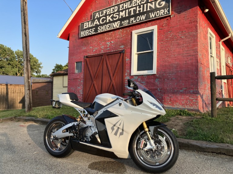 Strike R on the road beside a red barn