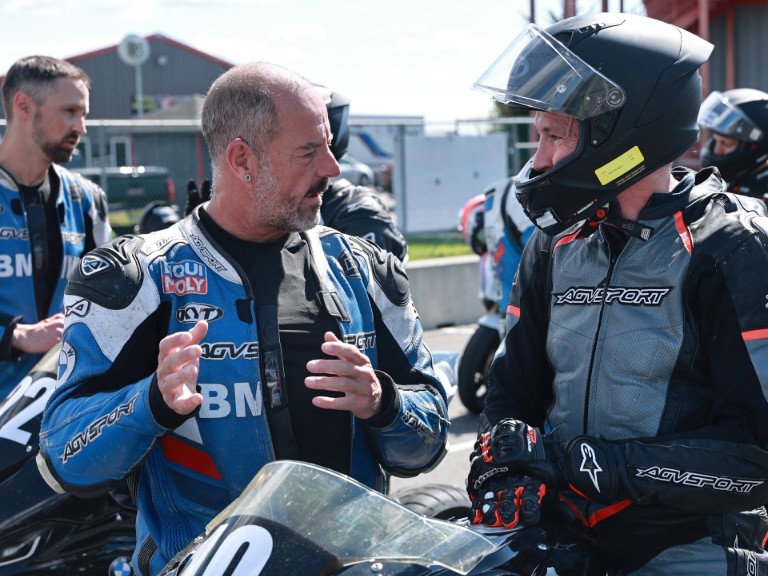 Coach delivering feedback to rider prior to going on-track
