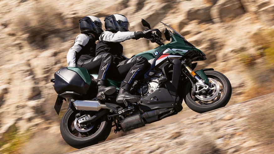 2026 BMW S 1000 XR on the road with rider and passenger.